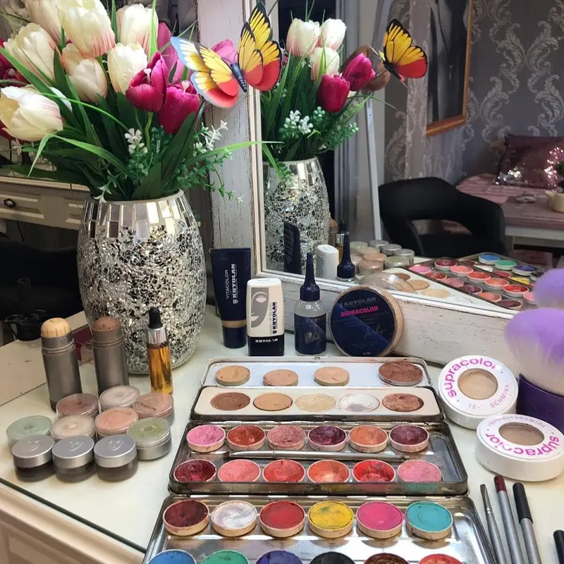A make-up table with colour palettes, brushes and tulips